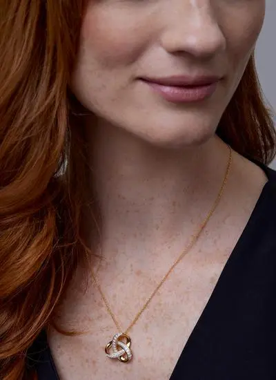Close up shot of red haired model wearing 14ct Gold Vermeil Trinity Knot Pendant with Cubic Zirconia